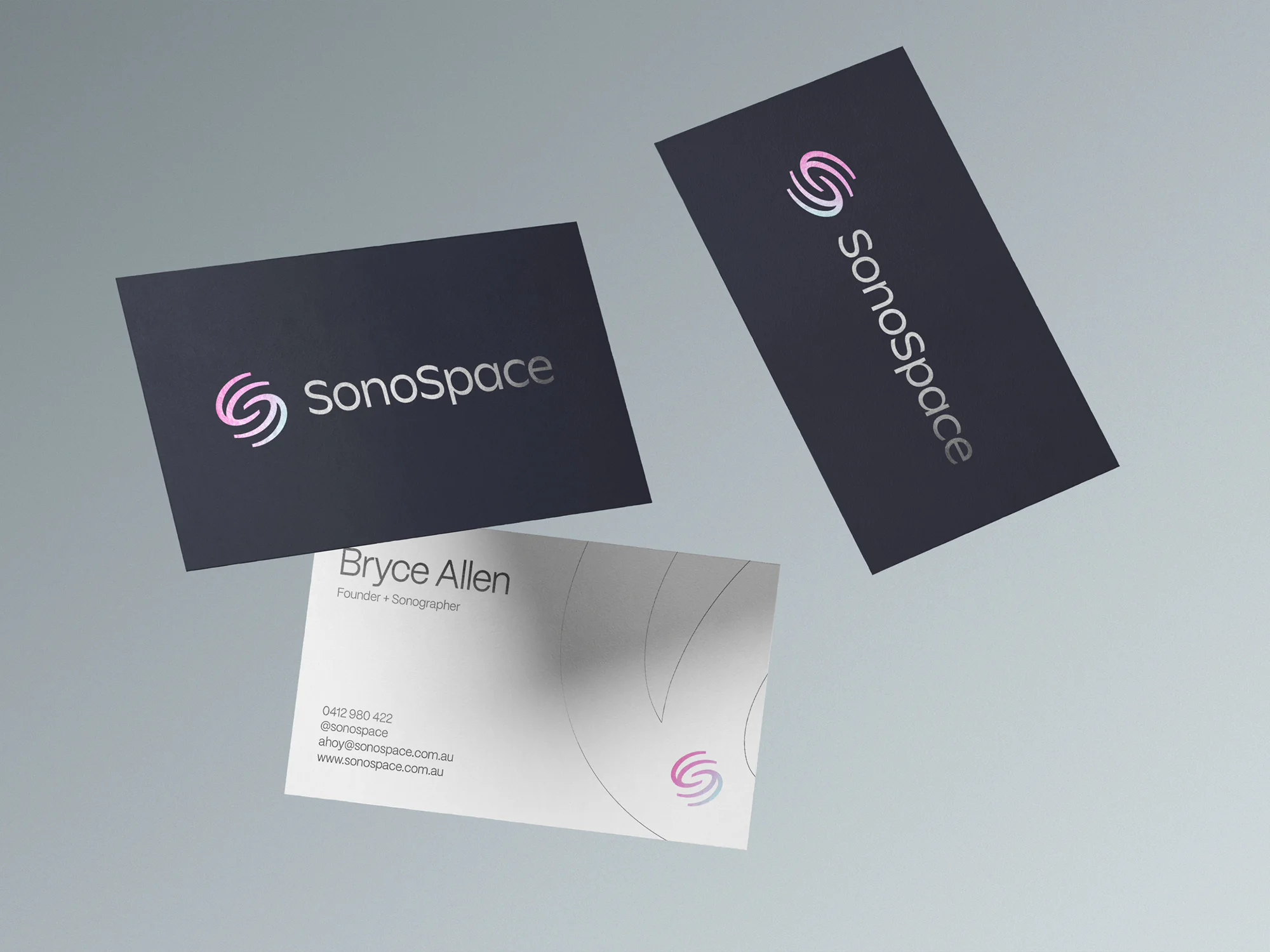 SonoSpace business cards for Bryce Allen, the iridescent logo foiled on navy stock.